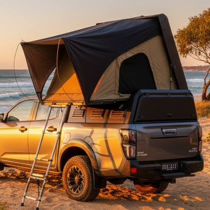 SUV ute with a rooftop canopy on a beach at sunset