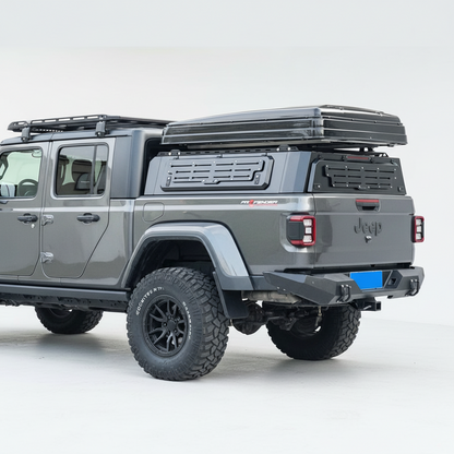 Silver off-road ute with a hard roof rack canopy on a street.