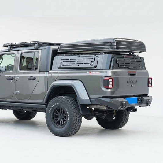 Silver off-road ute with a hard roof rack canopy on a street.