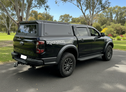 Black Ford Ranger Raptor ute truck with aluminium canopy with a clear background