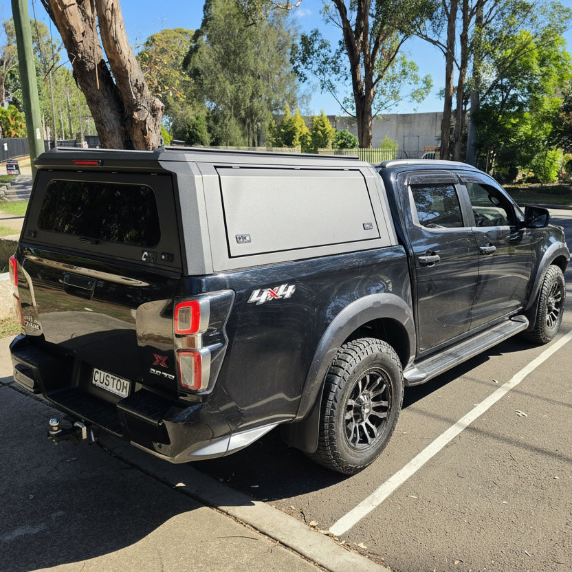 custom canopies black ute with plain side panel Black pickup truck with a canopy in a parking lot with trees in the background