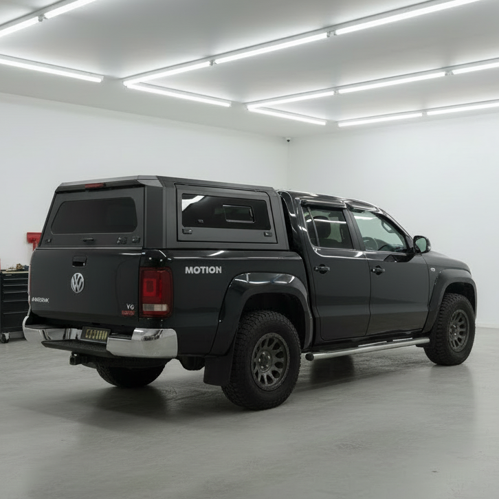 Black Volkswagen Amarok with custom canopies' modular ute canopy and a roof rack in a garage setting